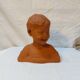 Terracotta bust of a smiling little boy.