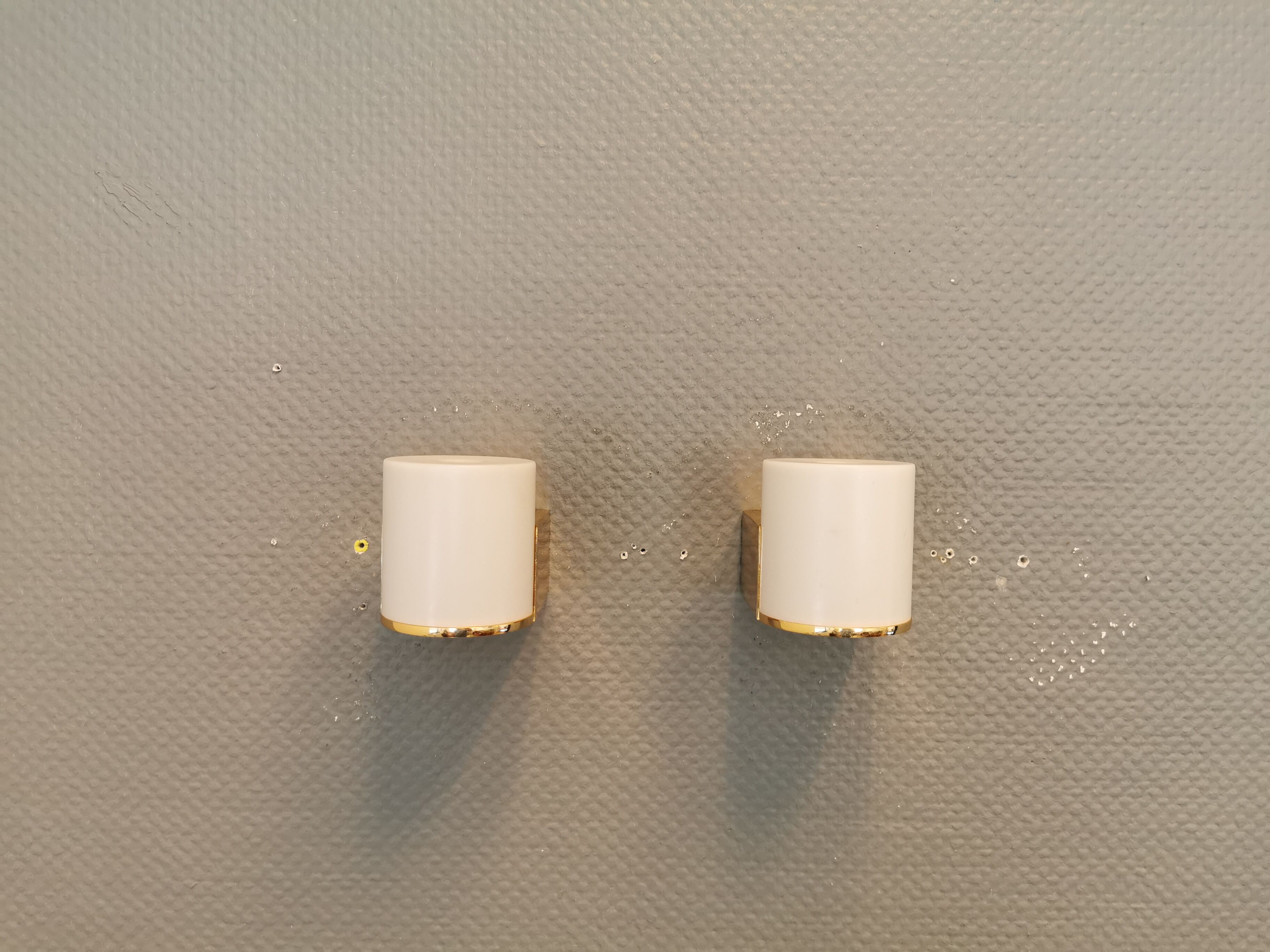 Wall lamps with milky white acrylic plastic shades and solid brass bases