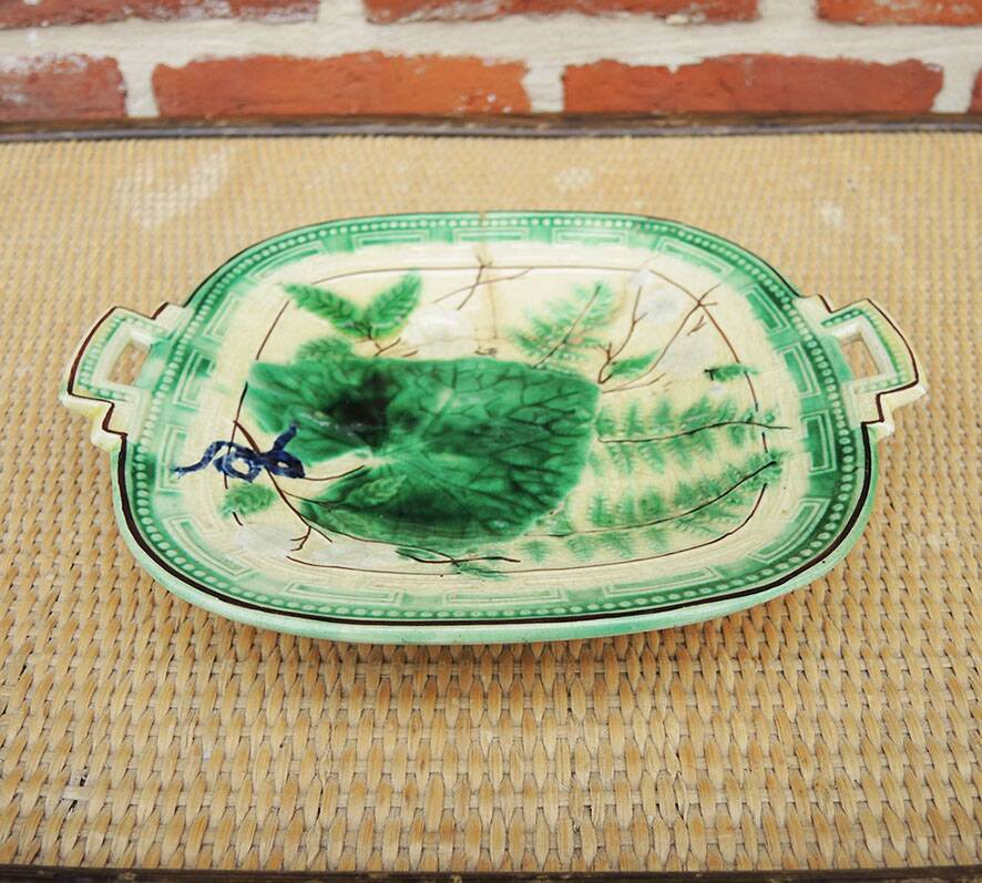 Old square plate in slipware with plant decoration.