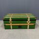 Green metal trunk with wooden sleds