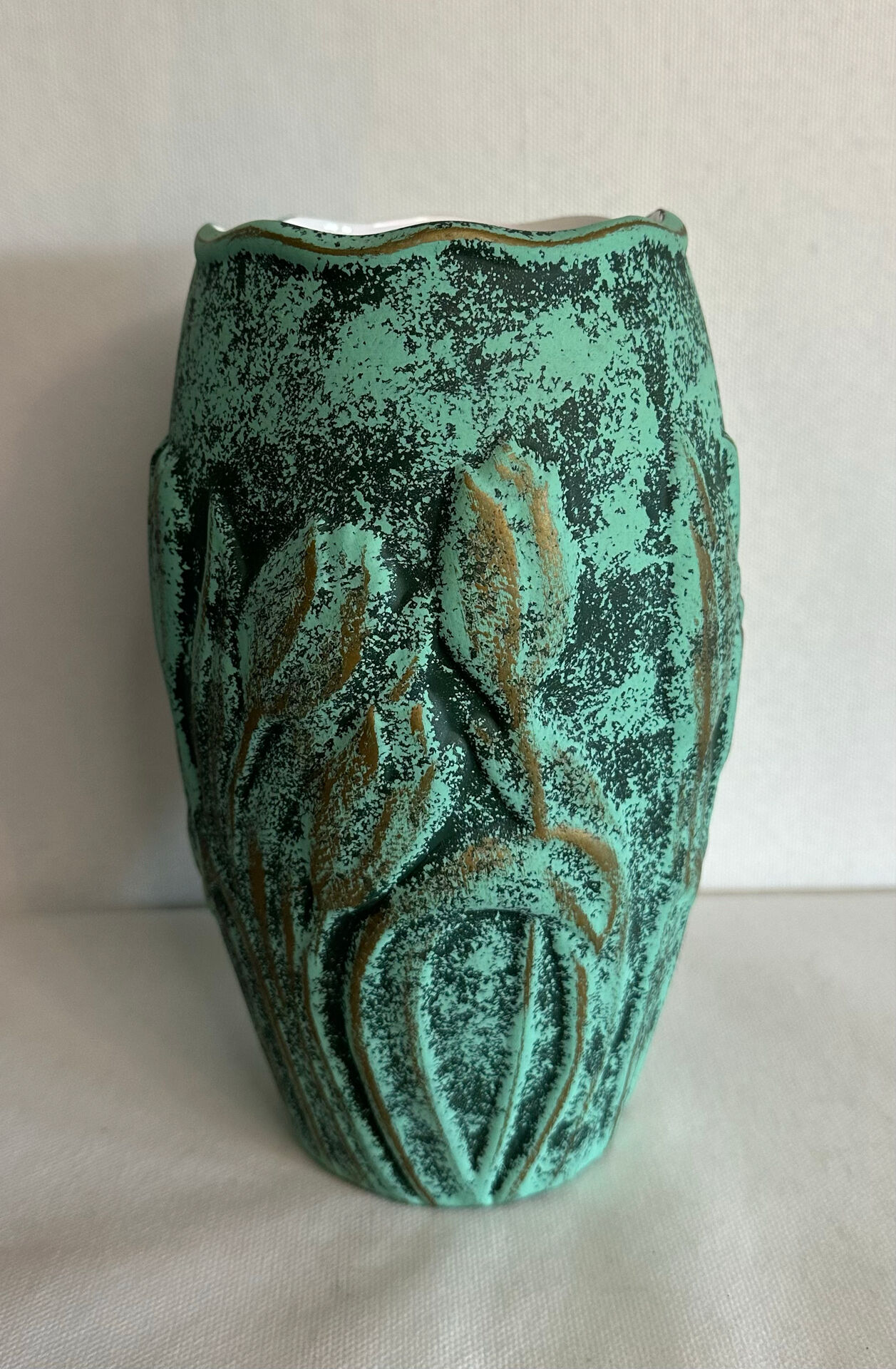 Vintage green patinated ceramic vase with raised floral decoration.