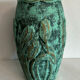 Vintage green patinated ceramic vase with raised floral decoration.