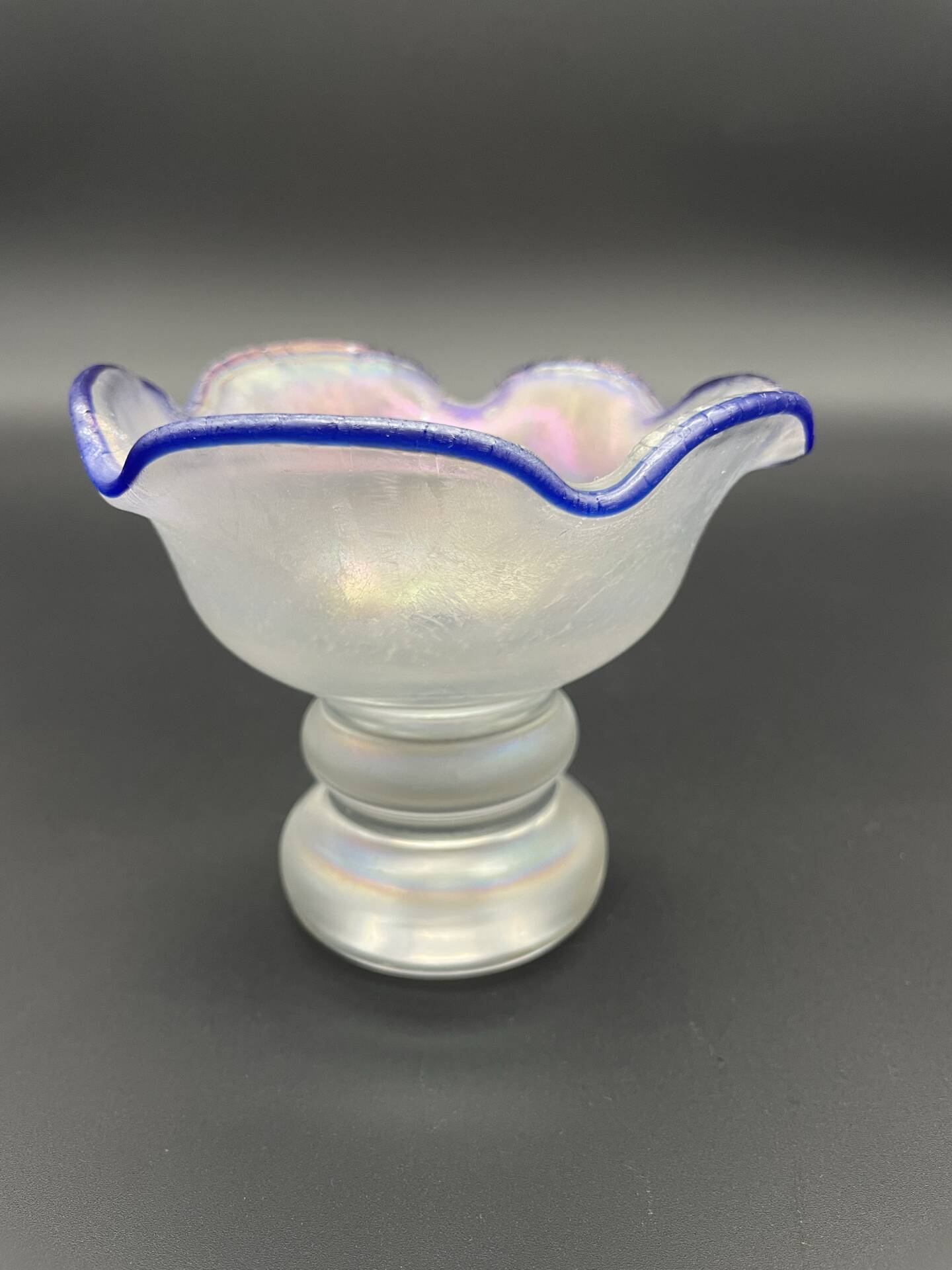 Eisch glass footed cup with pearlescent finish, blue rim.