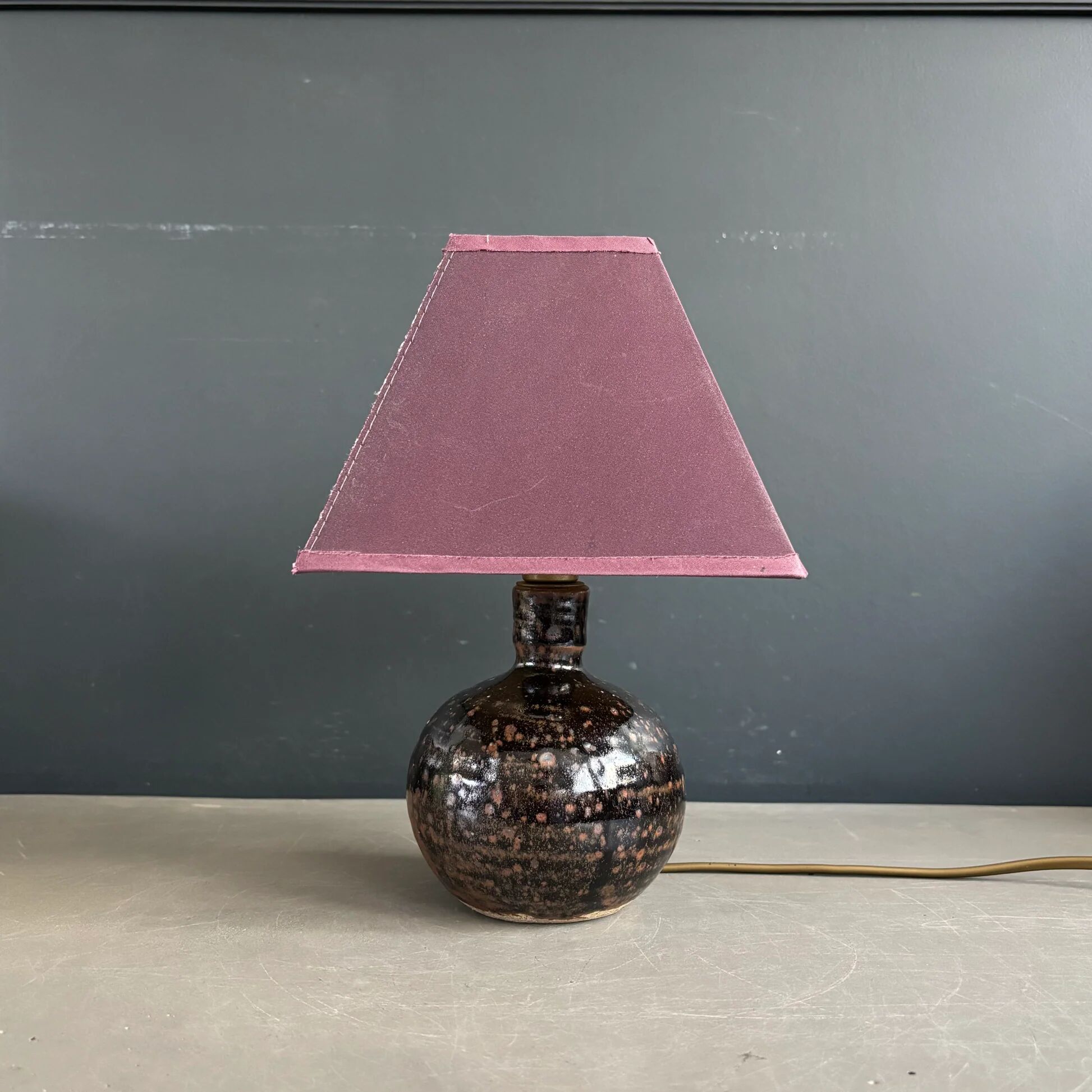 Ceramic floor lamp with a pyramidal shade and square base.