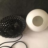 Table lamp with black porcelain support in the shape of a woven basket and opaque glass ball globe