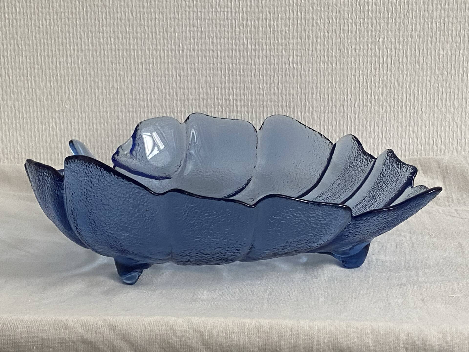 Large leaf-shaped fruit bowl, made of moulded blue glass.