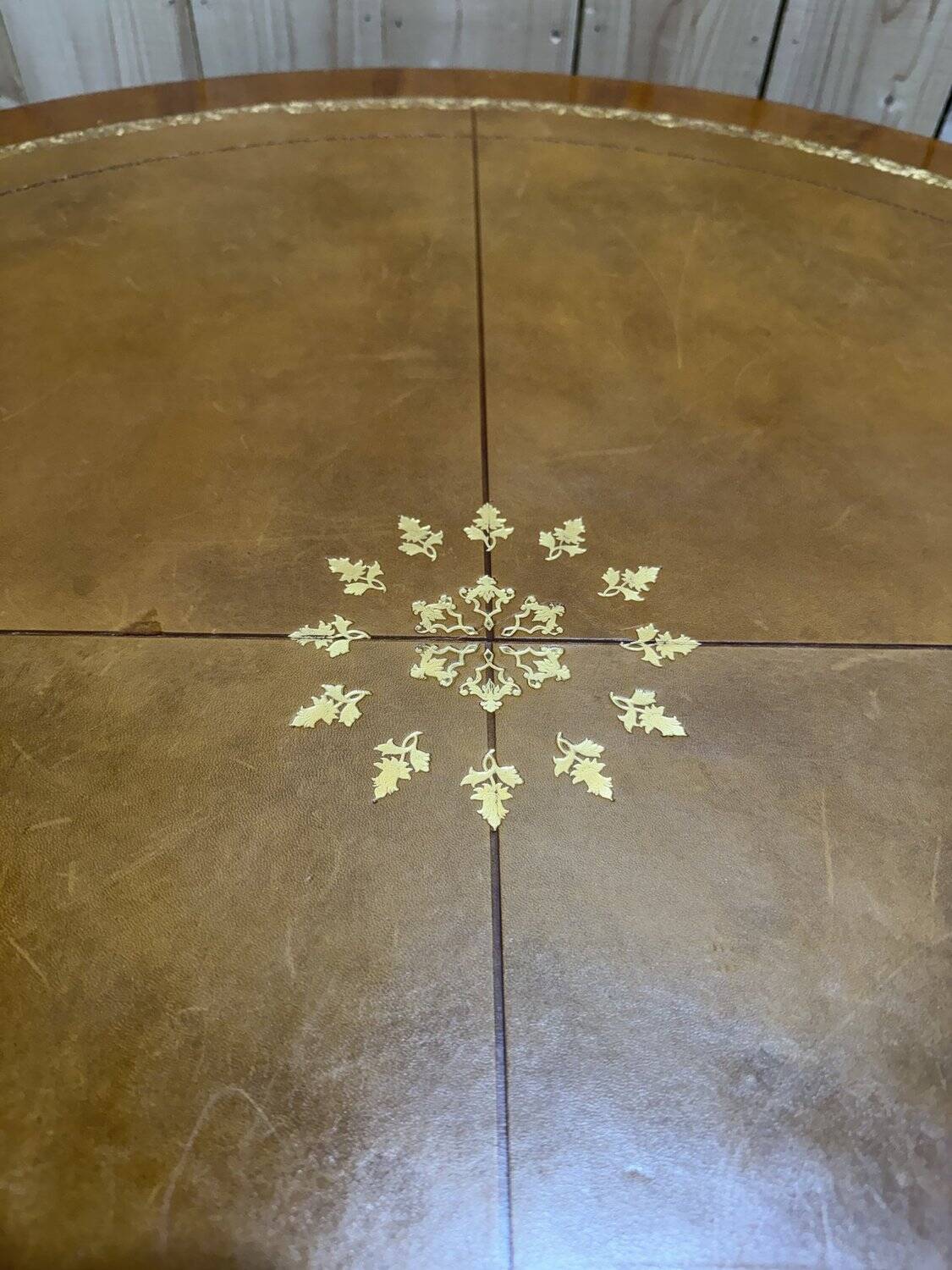 Round dining table with leather top in Louis XVI style.
