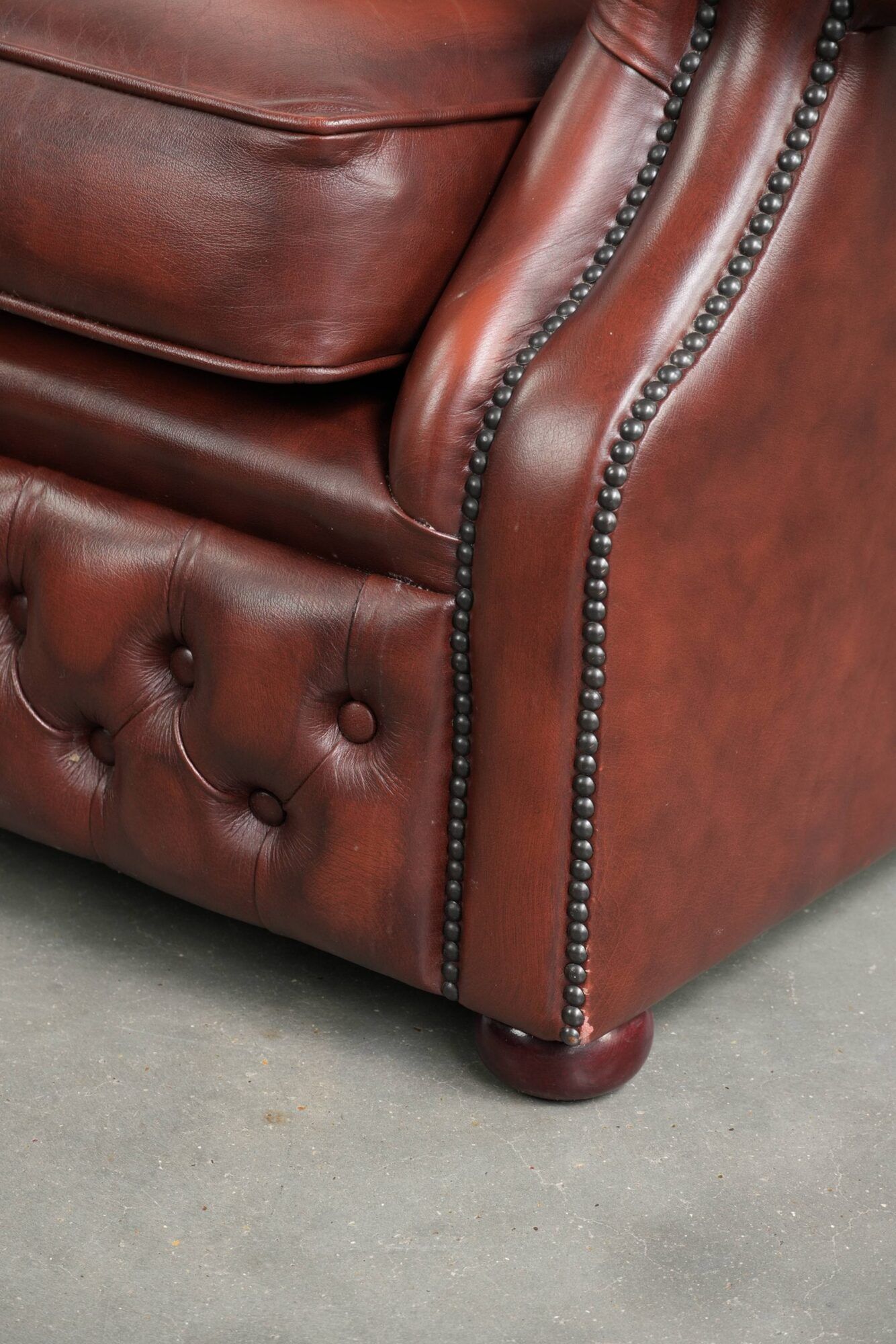 Cowhide chesterfield armchair in a warm brown colour with decorative nails
