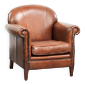 Sheepskin armchair with comfortable seat and finished with decorative nails