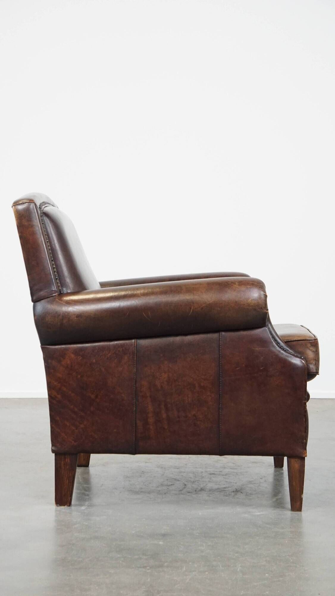 Dark brown sheepskin armchair finished with decorative nails
