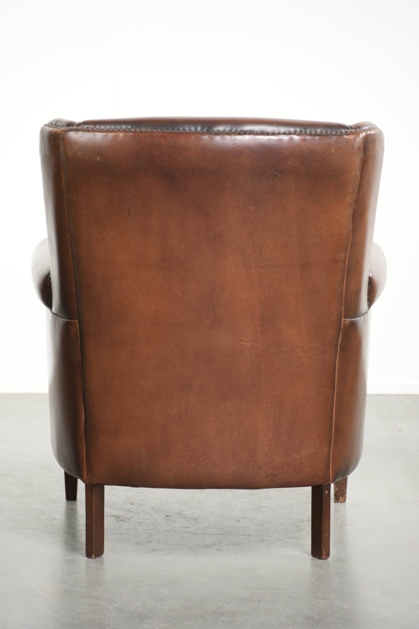 Subtle dark brown sheepskin wingback armchair with a timeless look subtle