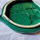 A trivet and two bottle holders in green Vallauris majolica.