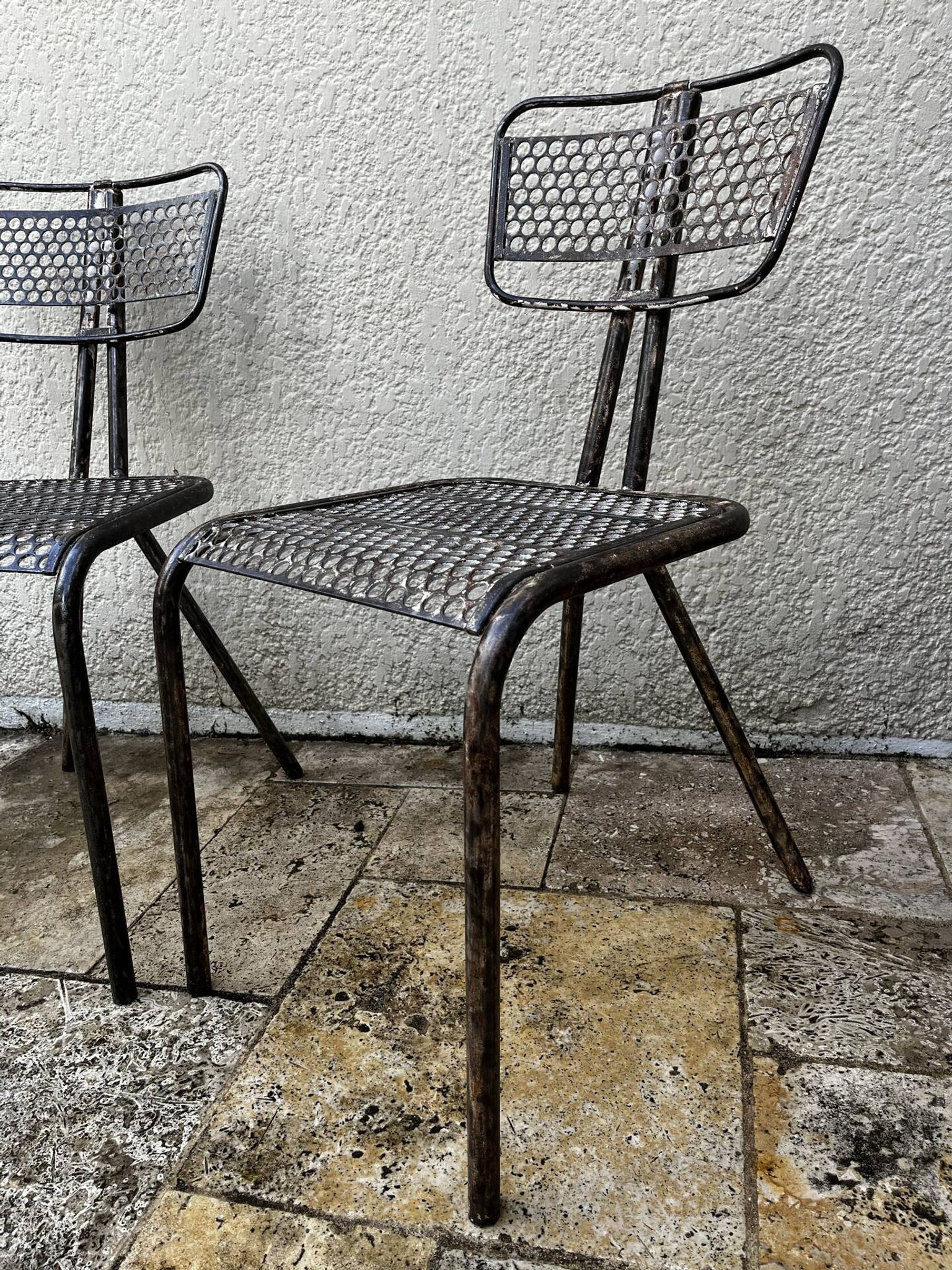 Pairs of perforated metal chairs by René Malaval