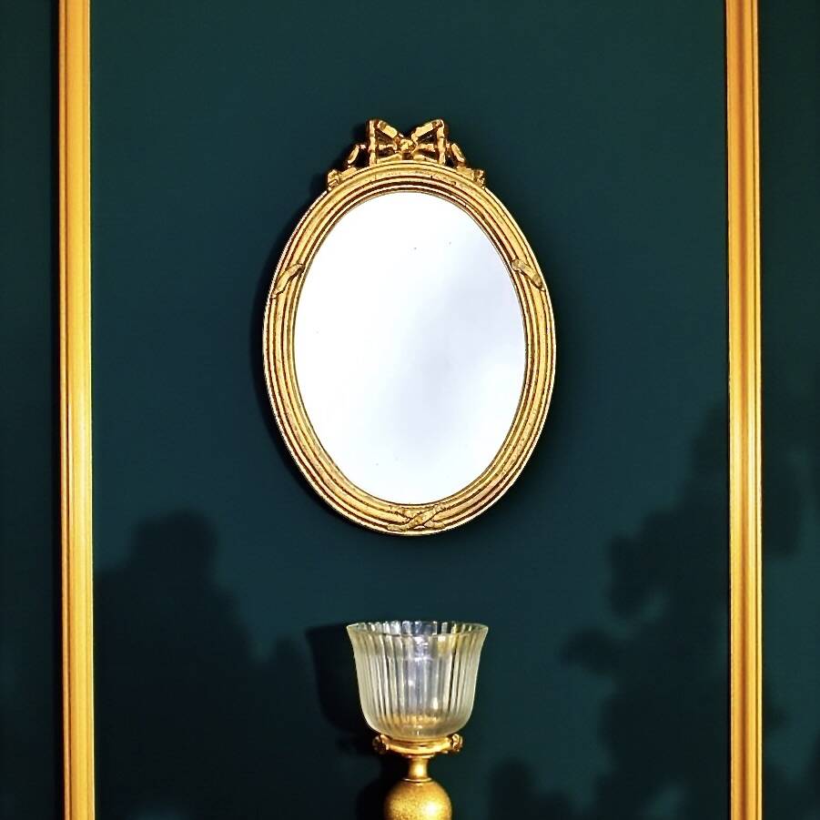 Antique oval mirror in gilded resin with Louis XVI style knot decoration