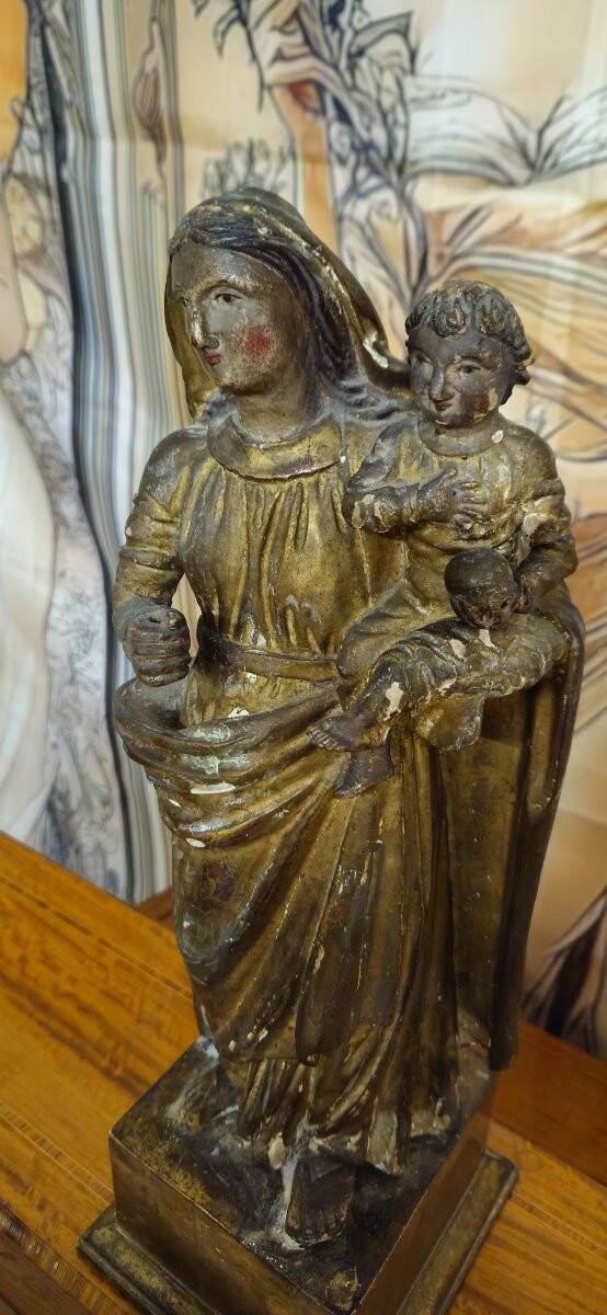 Ancient statue of the Virgin and Child in polychrome and gilded carved wood.