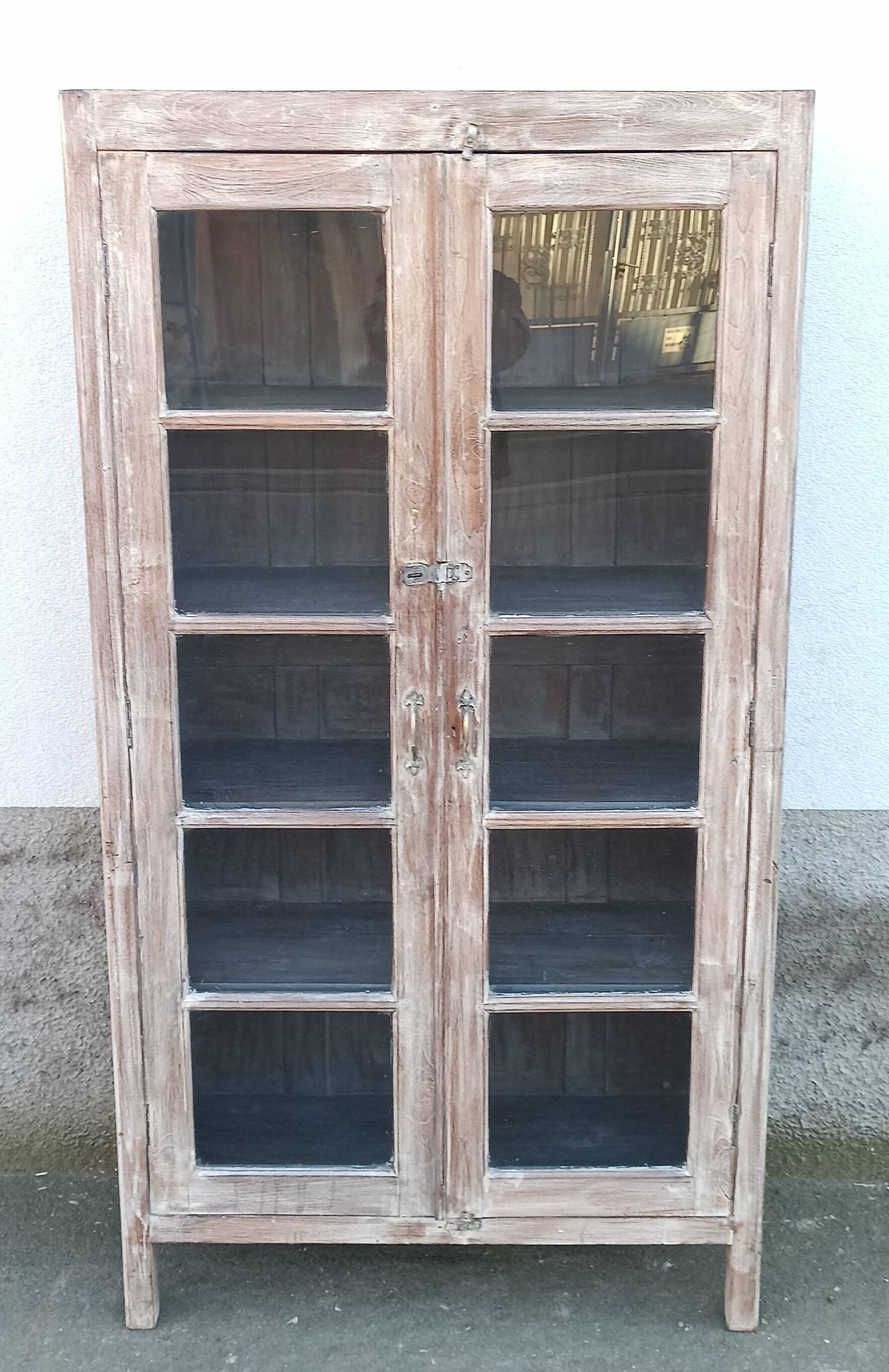 Glass cabinet in old whitewashed wood