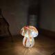 Mosaic glass mushroom lamp in orange, white, and clear.