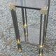 Pair of Hollywood Regency side tables in gold metal and smoked glass.