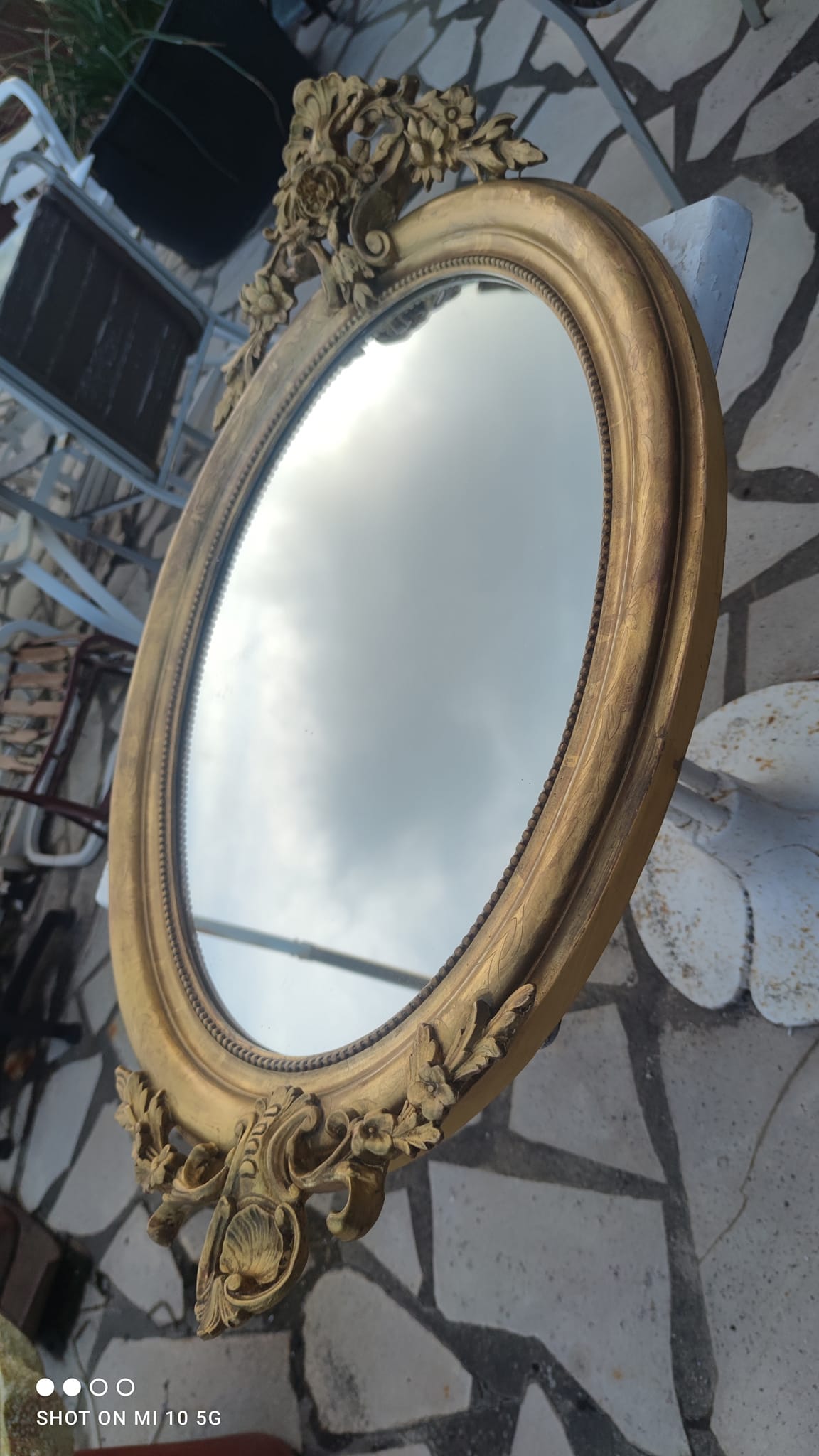 Ovoid mirror with double gilt pediments, circa 1830, 105x66 cm