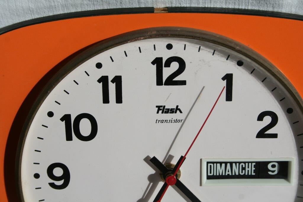 Vintage wall clock in orange formica