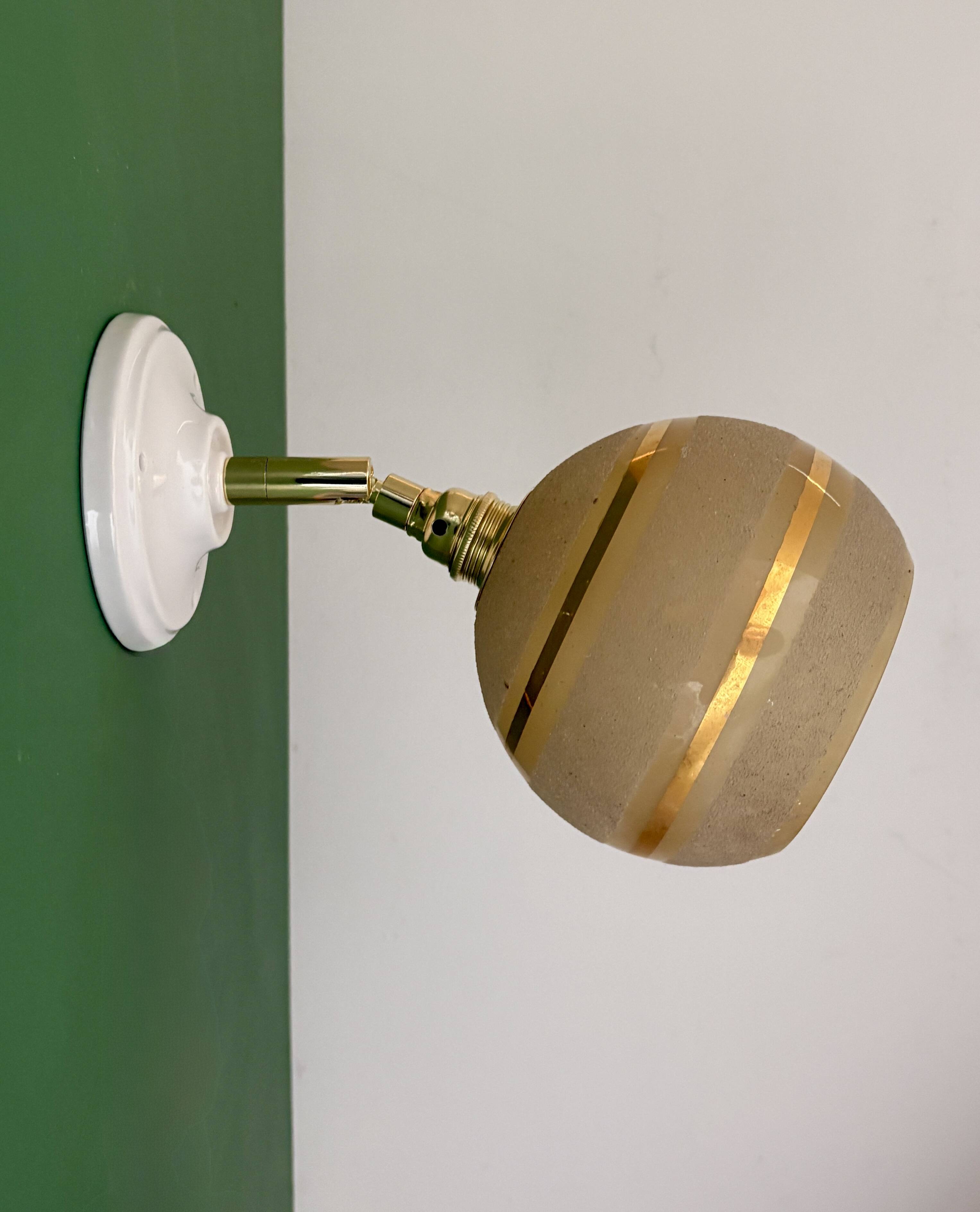 Vintage globe wall light in frosted yellow and gold glass.