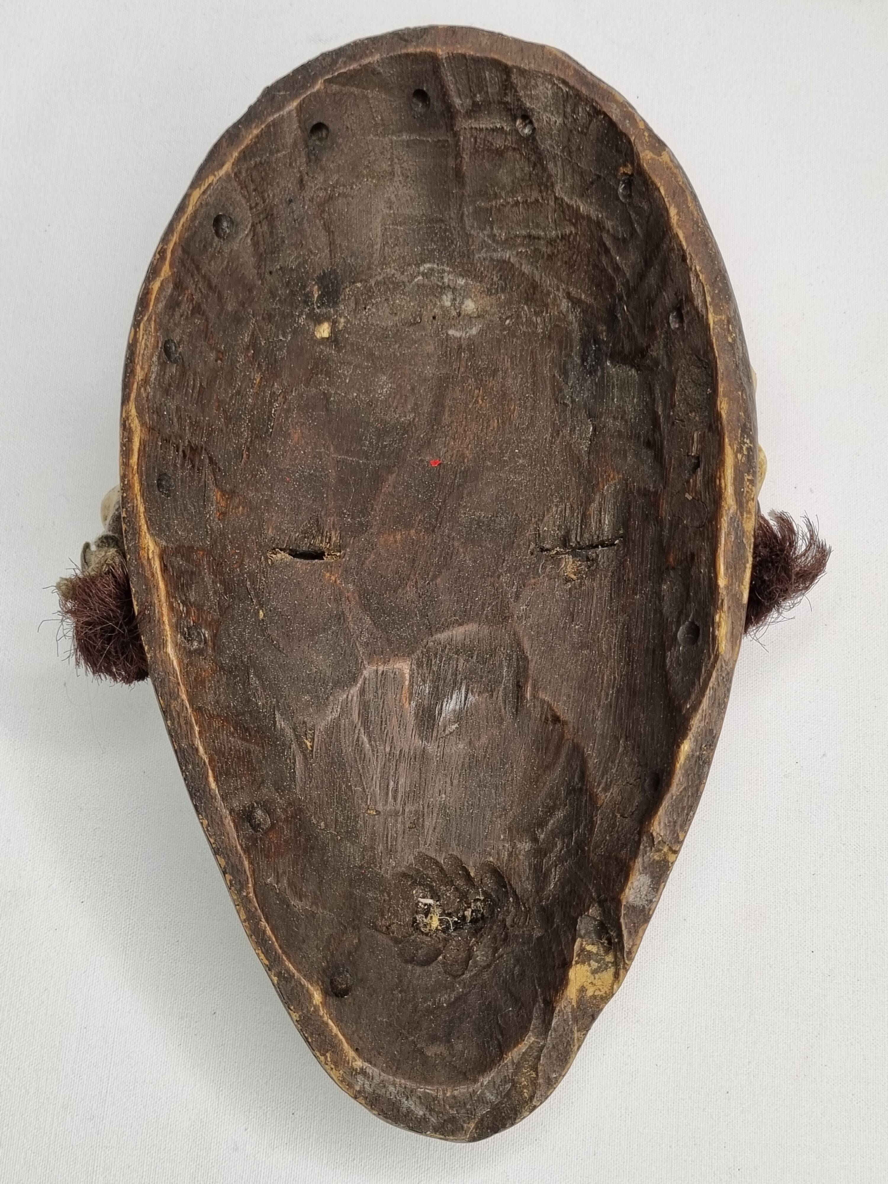 Tribal Dan mask in wood and cowrie shells, West Africa, 27 cm