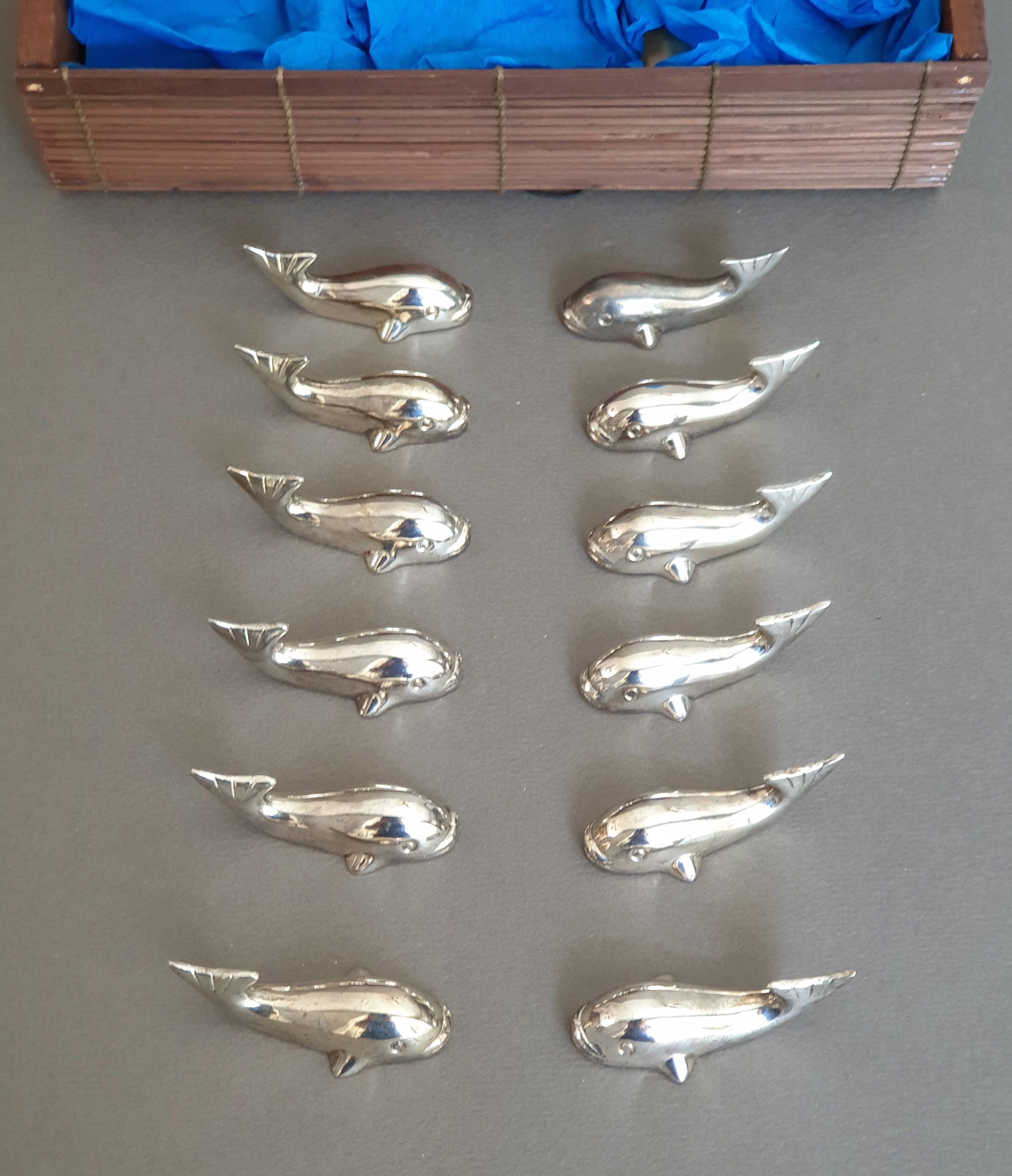 Lot 12 knife holders in the shape of a stylized whale or fish