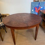 Oval extendable dining table in wood and walnut burl veneer.