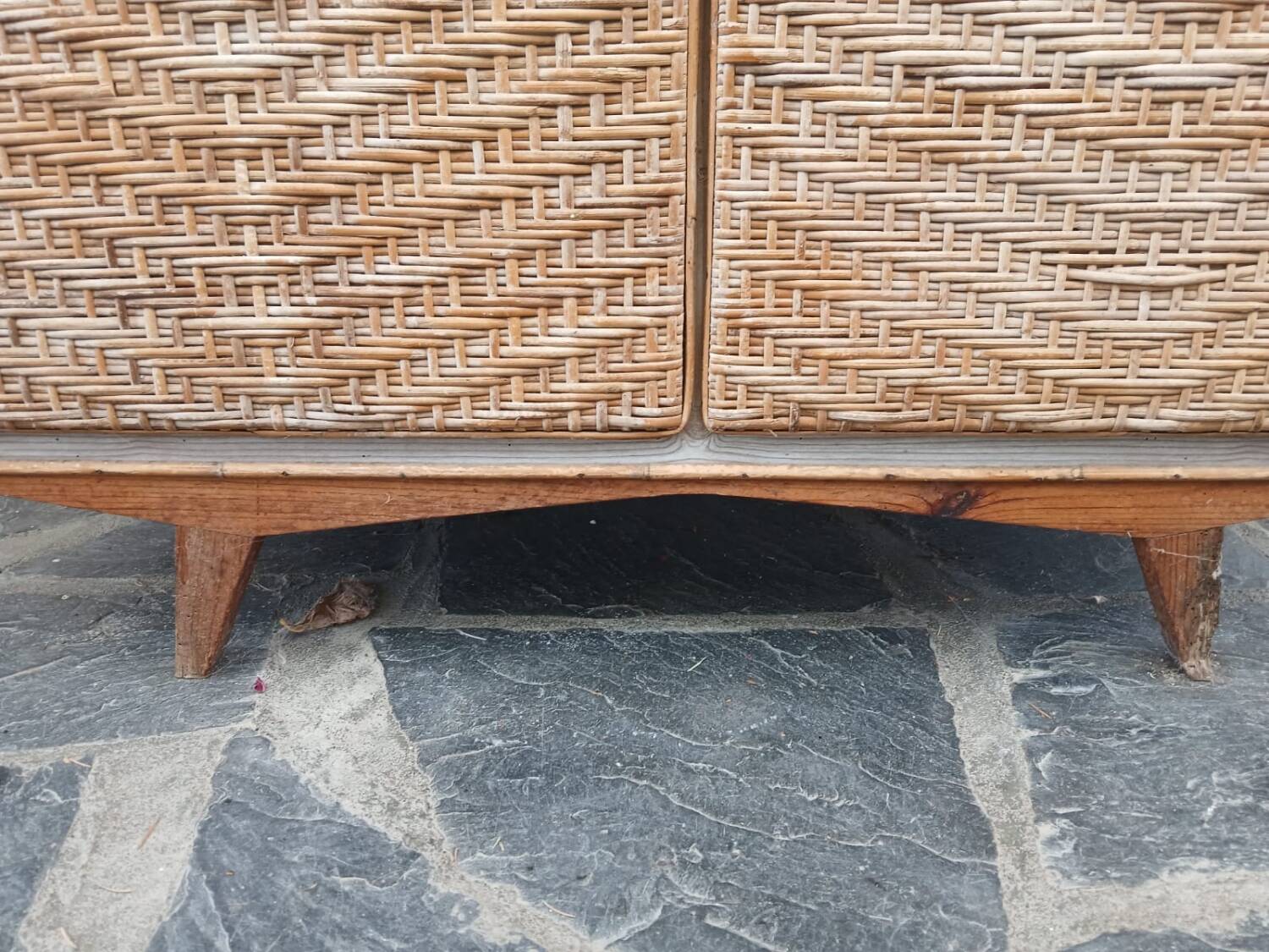 Vintage woven rattan furniture with tapered legs.