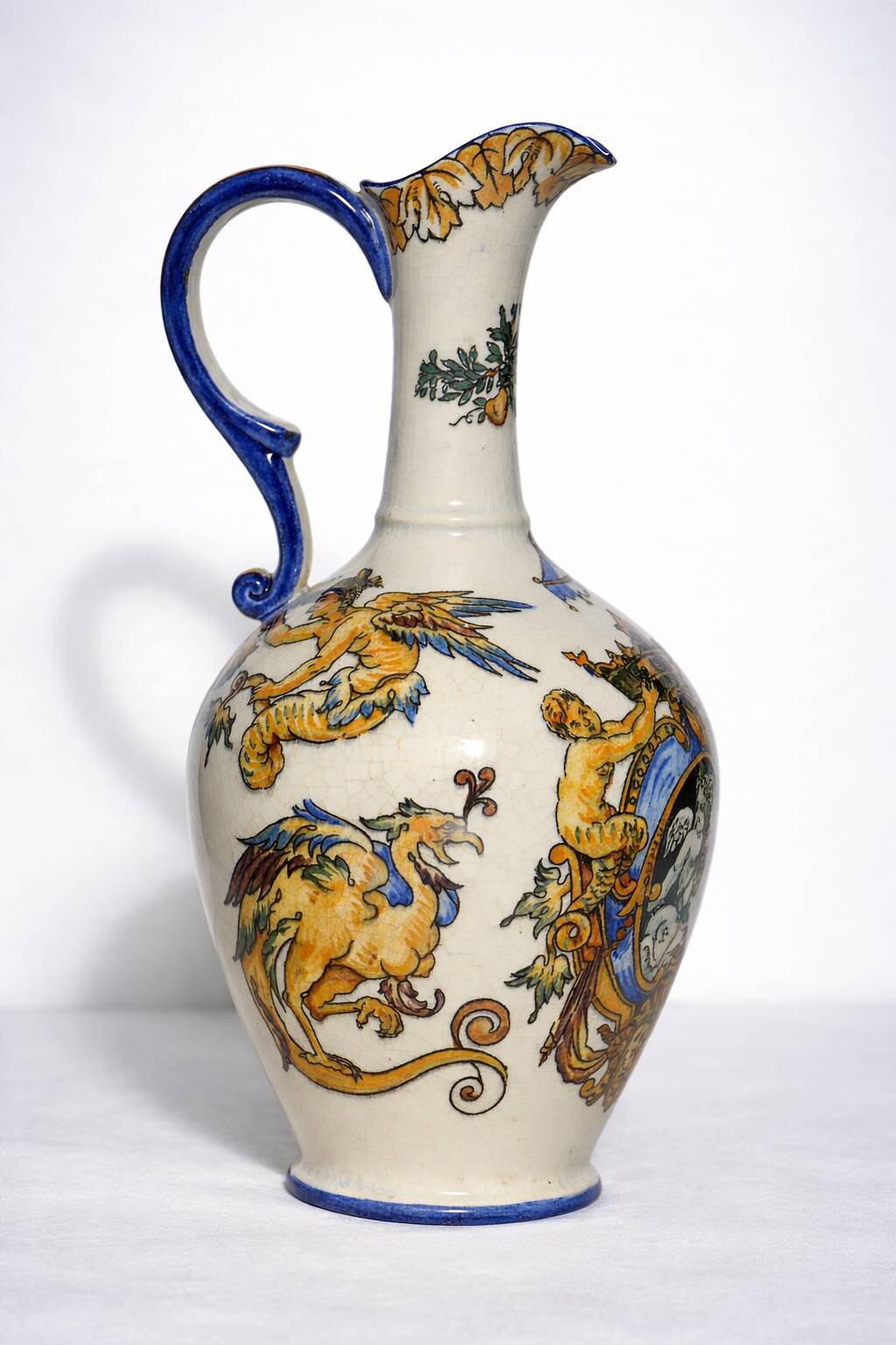 Gien earthenware jug, Renaissance decoration, putto with dolphin.