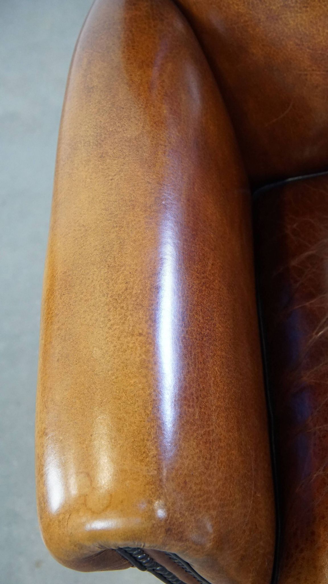Sheep leather design armchair finished with decorative nails and black piping