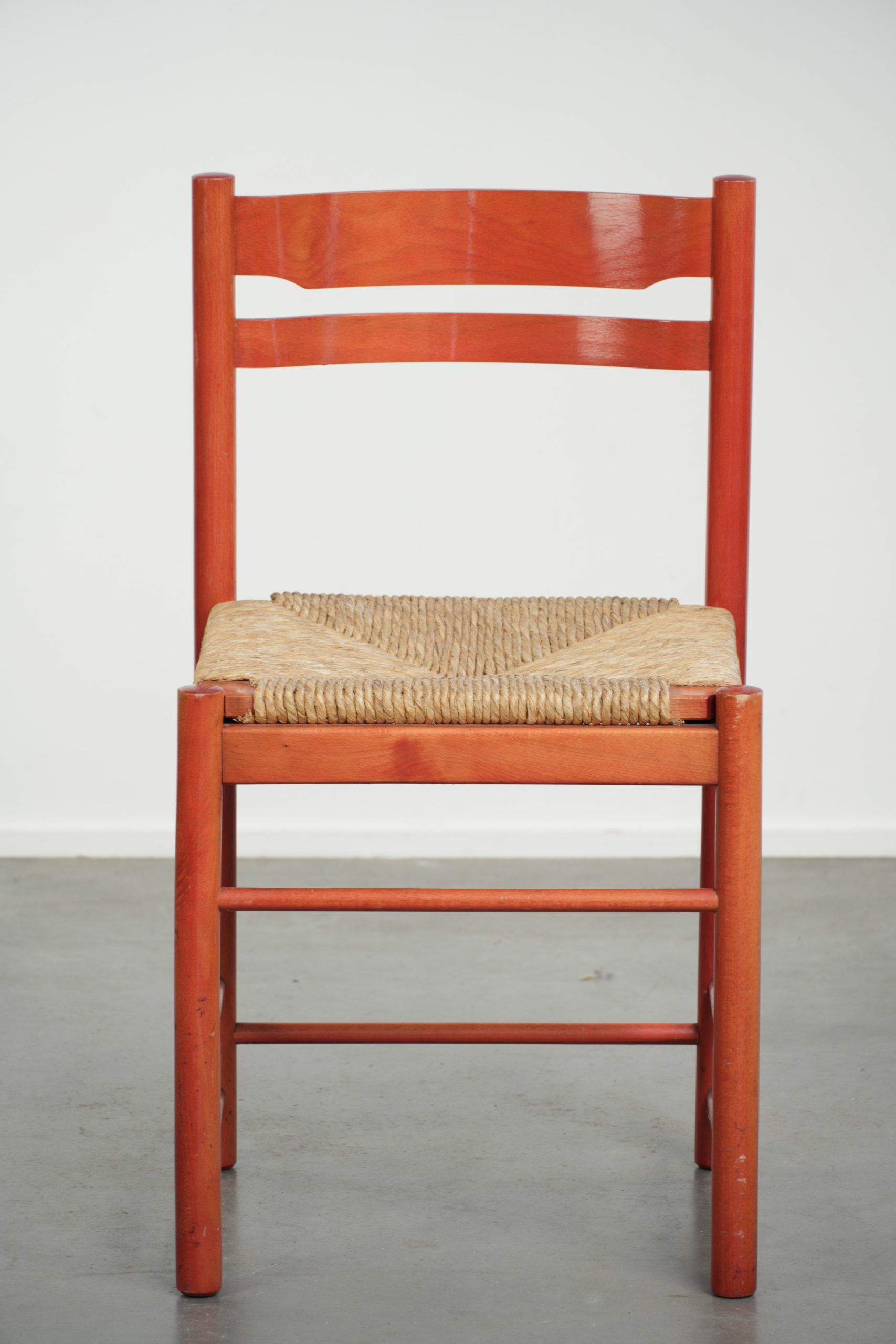 Nice red vintage wooden chair from the 1970s with a woven wicker seat