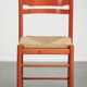 Nice red vintage wooden chair from the 1970s with a woven wicker seat