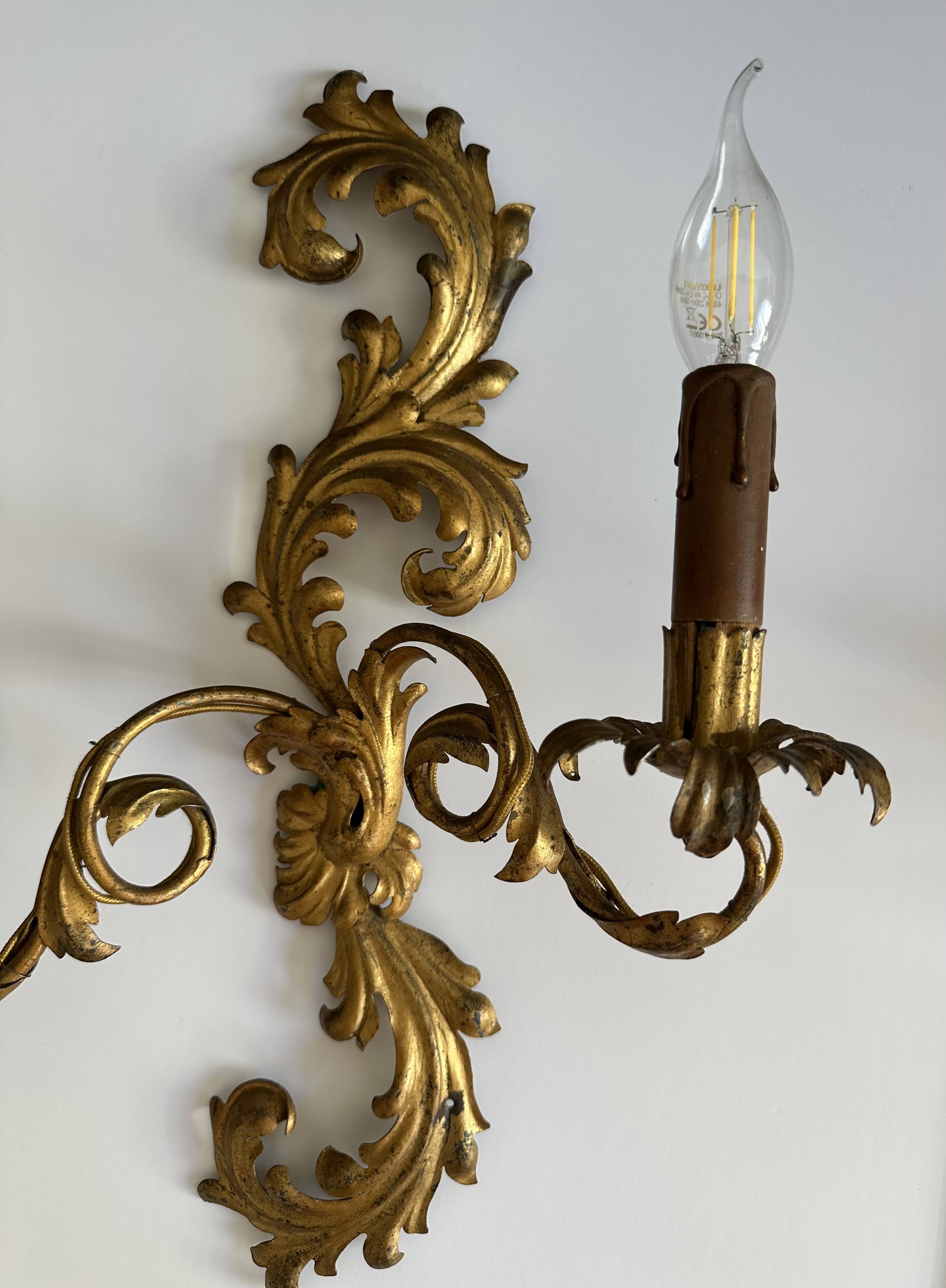 Pair of Italian Hollywood Regency wall lights in iron and gilded sheet metal.