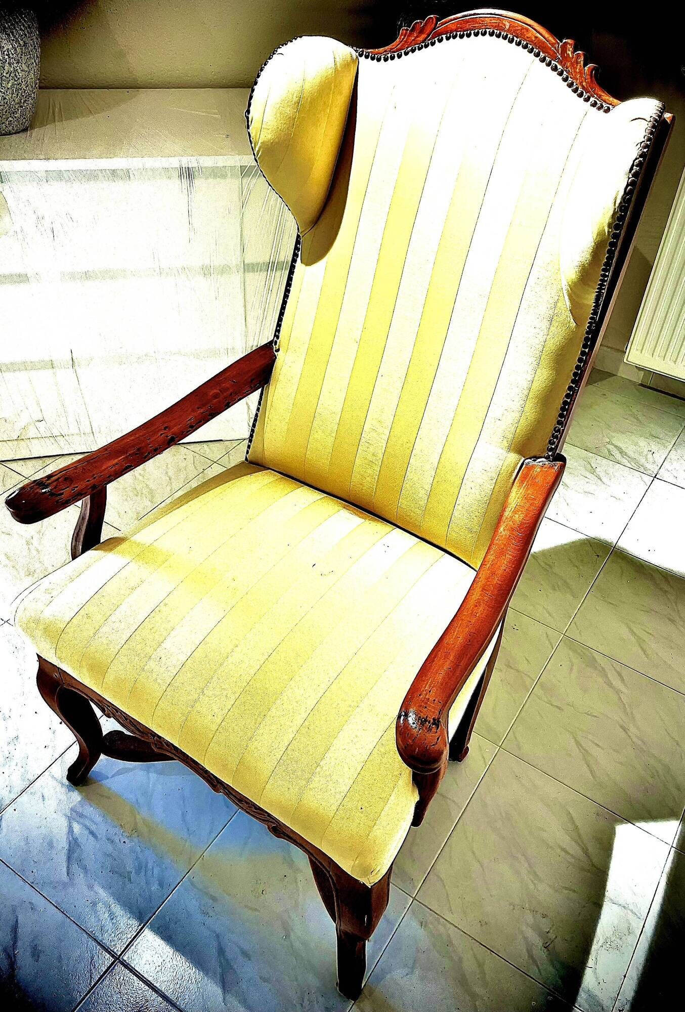 Wingback armchair in walnut in the French Regency style with stretcher in
