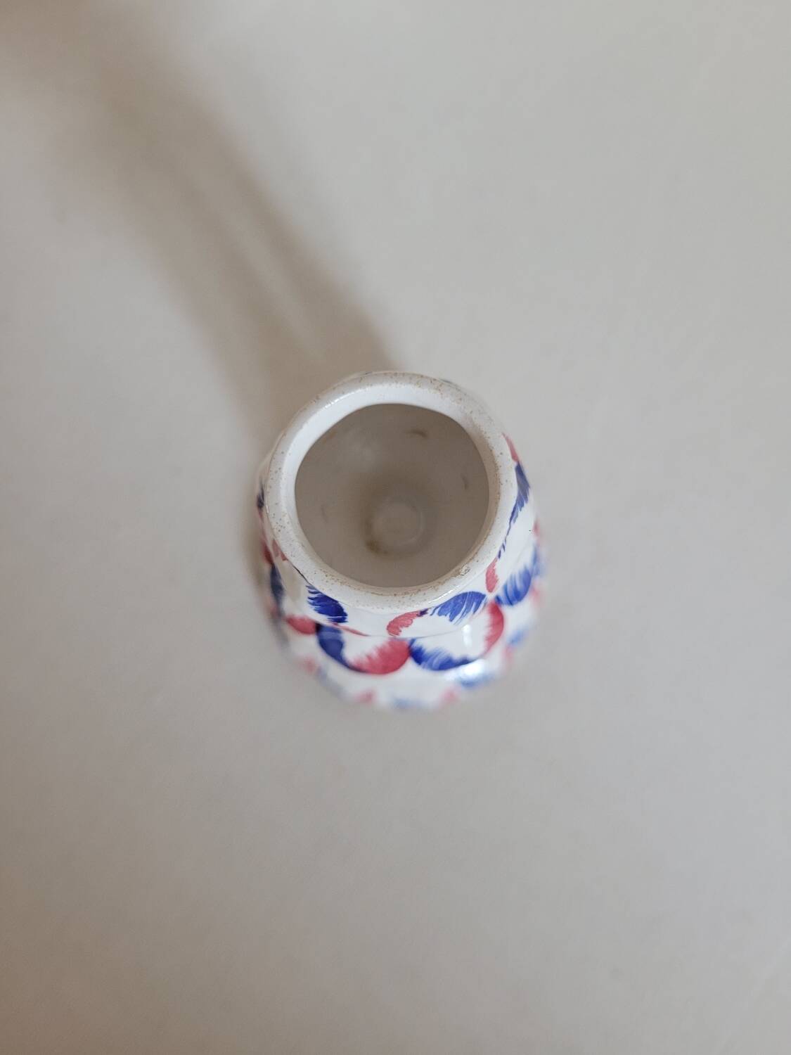 Ceramic candlestick with red and blue decoration.