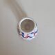Ceramic candlestick with red and blue decoration.