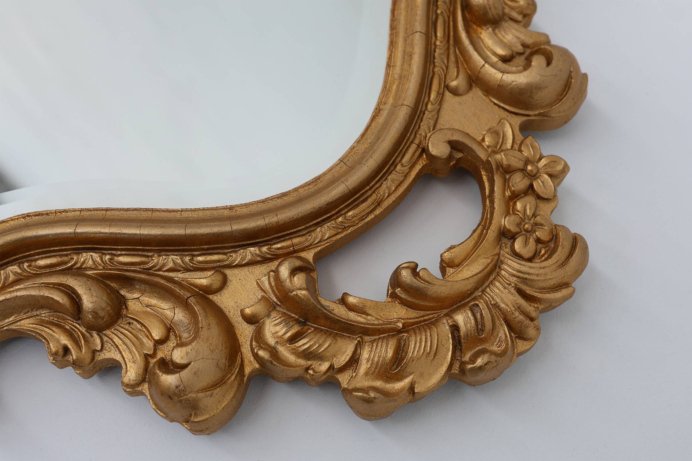 French Rococo or Baroque style facet-cut crest mirror in gilded carved wood