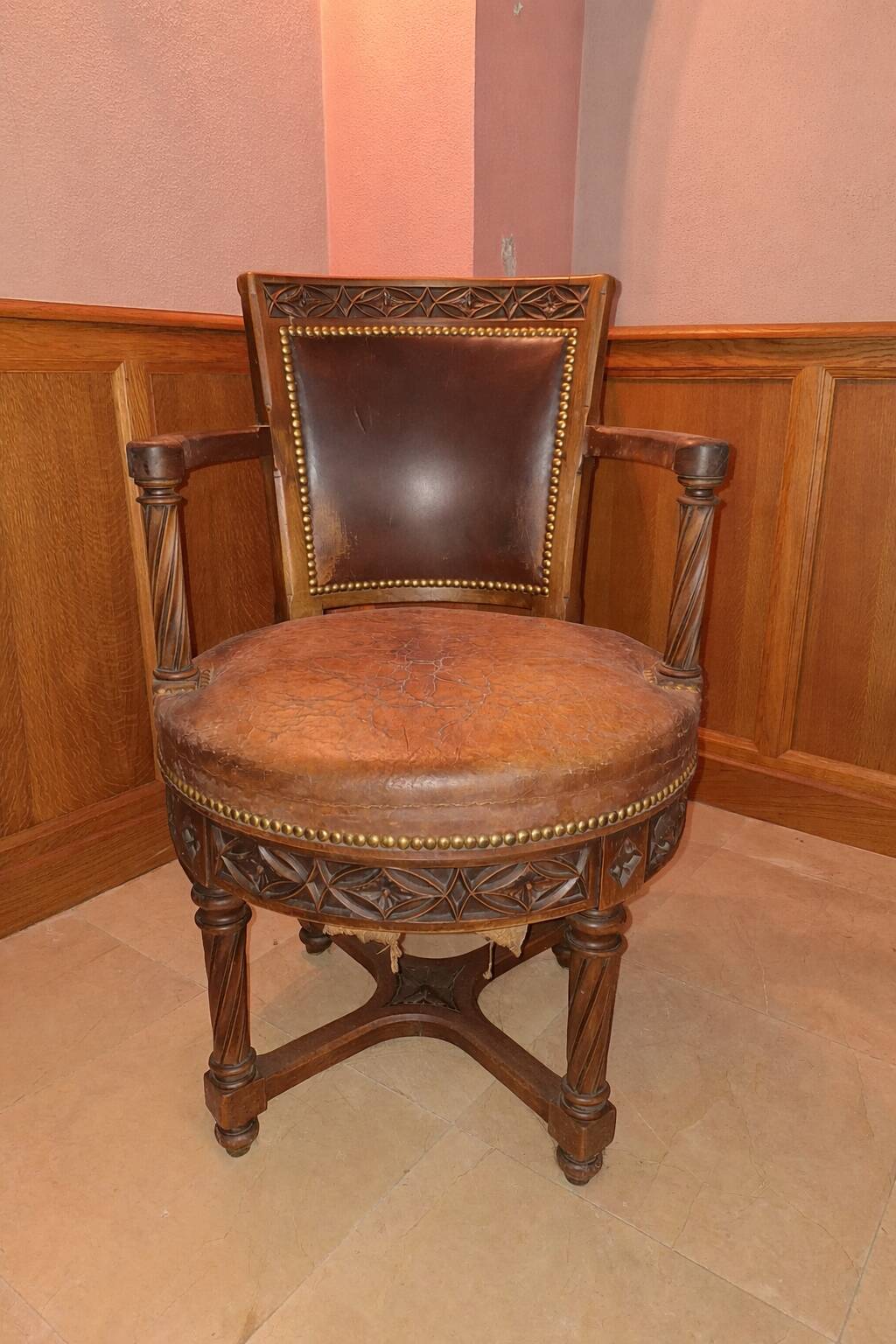 Antique swivel armchair in carved wood and patinated leather – neo-Renaissance style