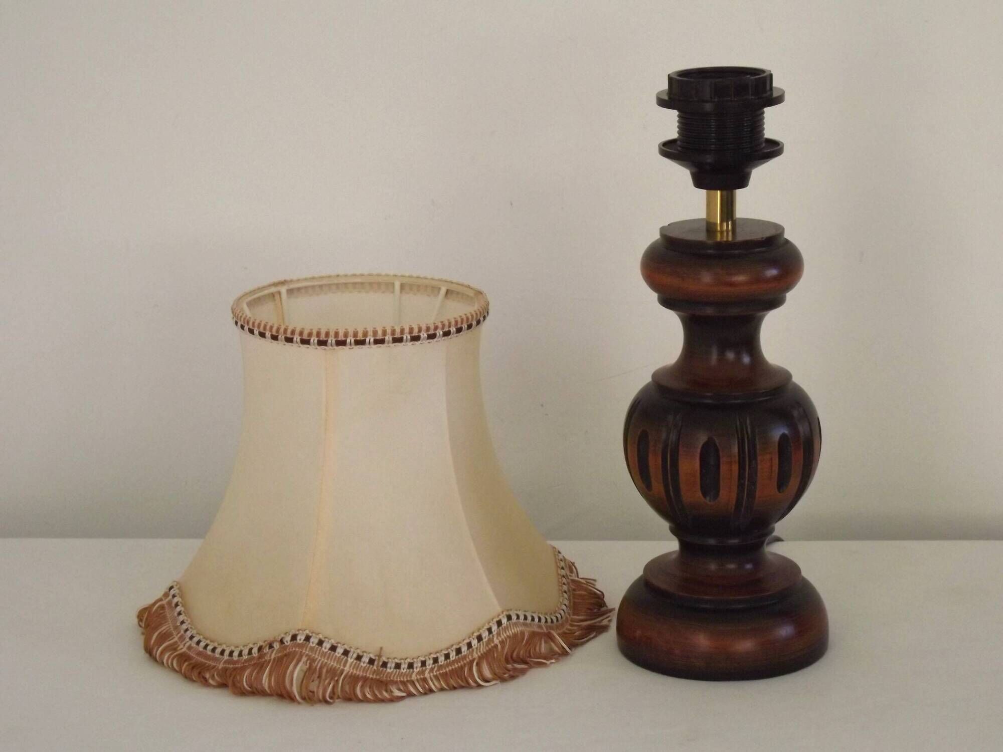 Mid-century French table lamp made of turned carved wood with a fringed shade.
