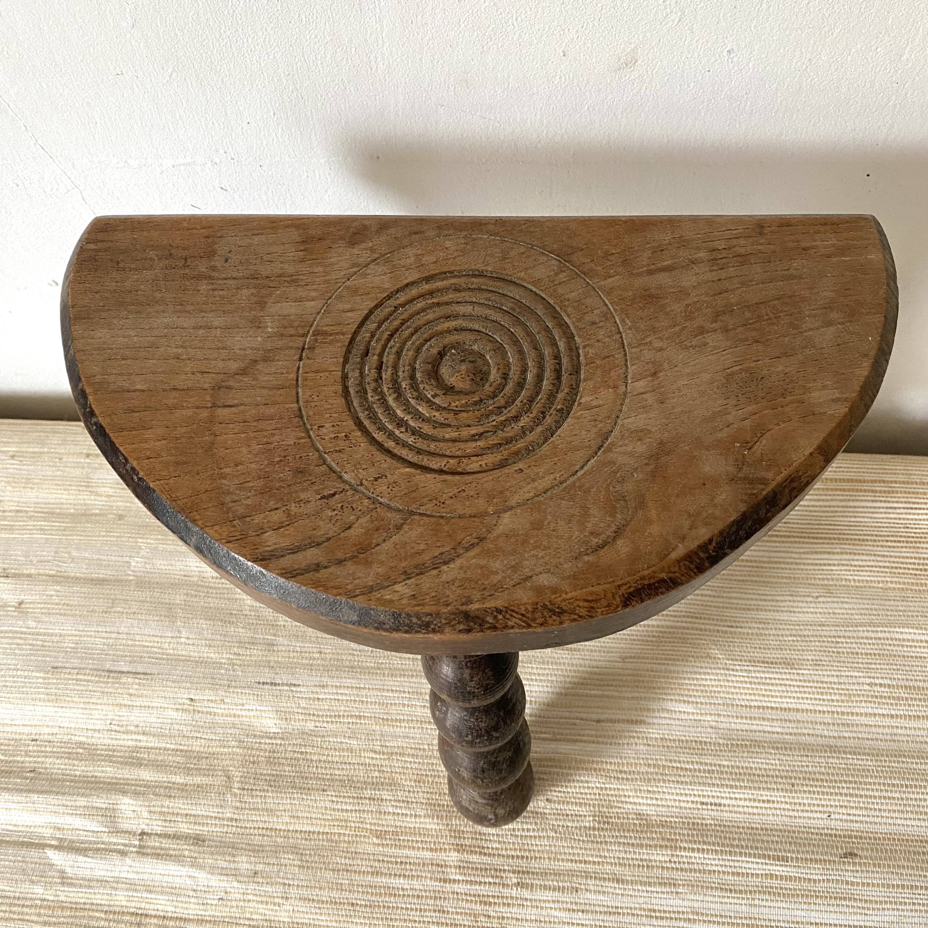 Tabouret tripode en bois sculpté, assise demi lune