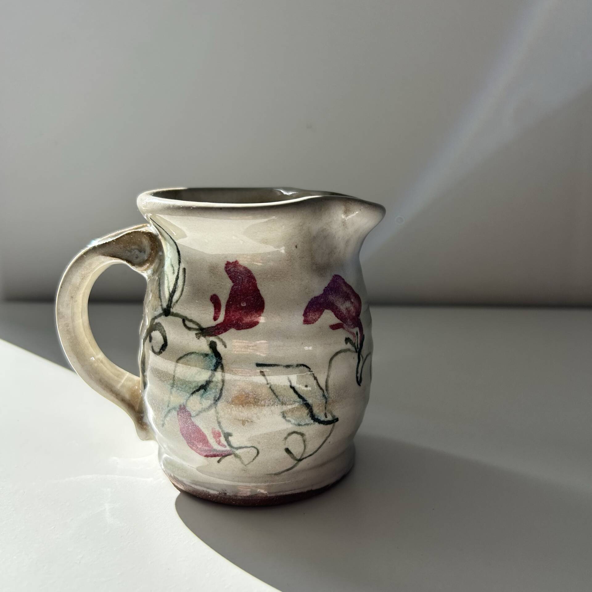 Floral decorated pitcher signed