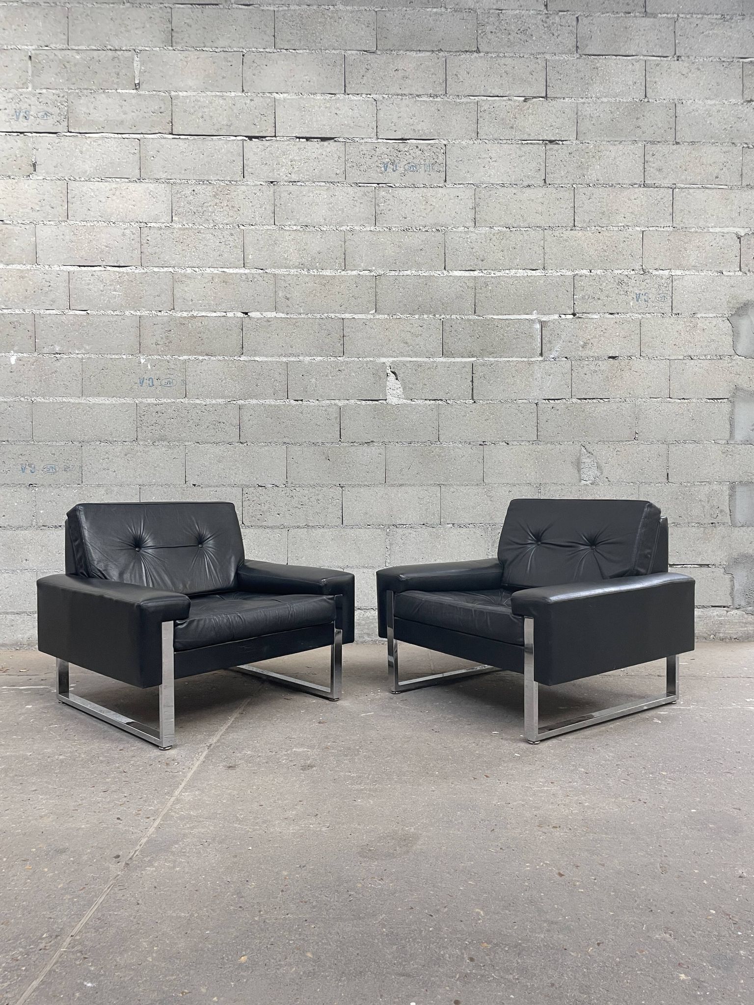 Pair of black leather armchairs