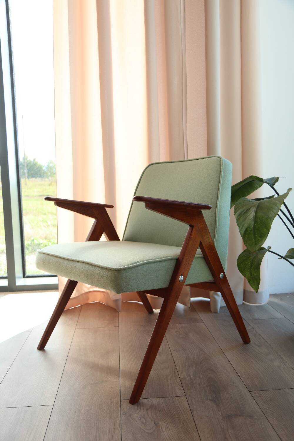 Vintage armchair in mint green wool, mid-century modern design.