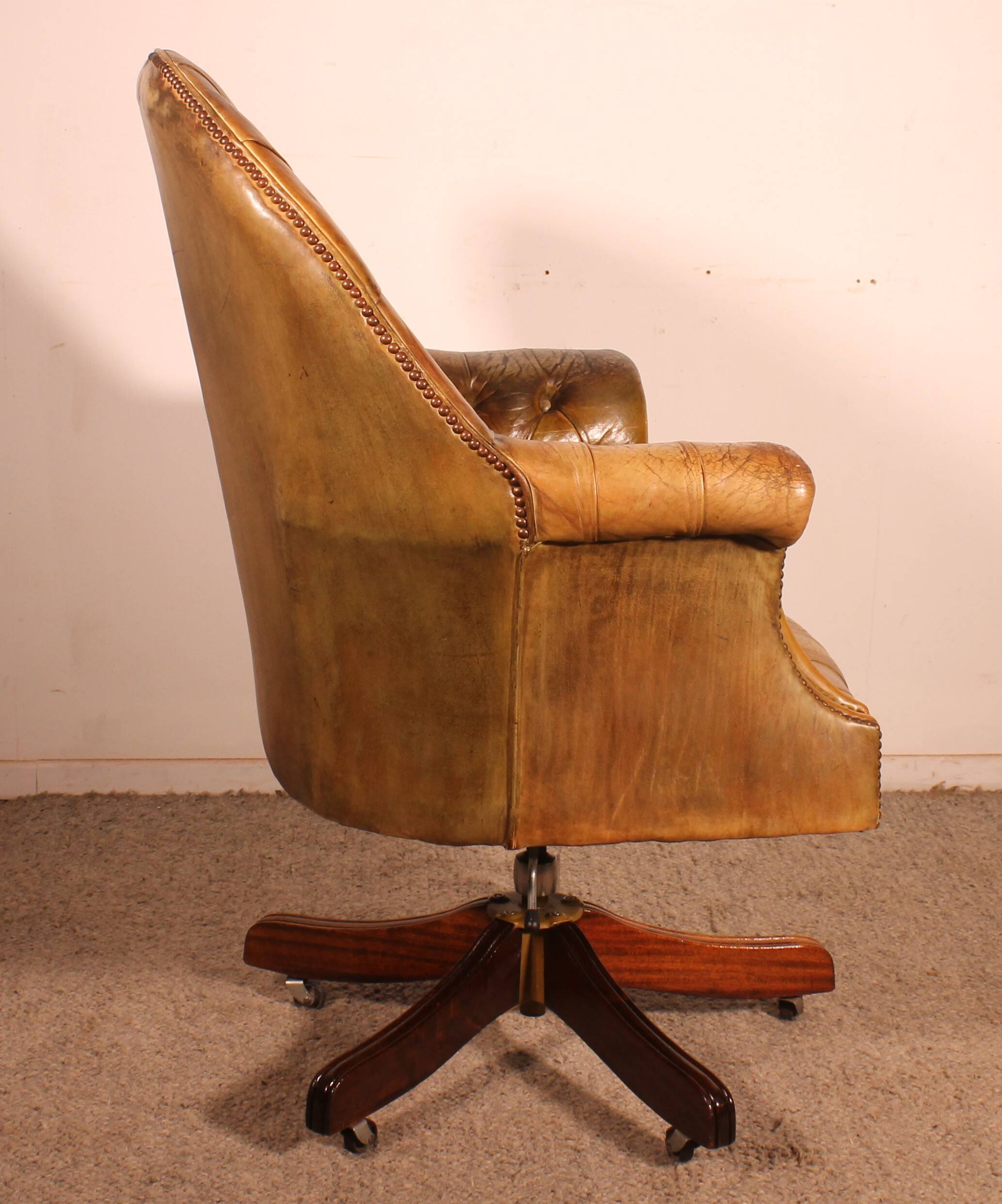 Office chair known as a presidential chair in mahogany and cognac leather.
