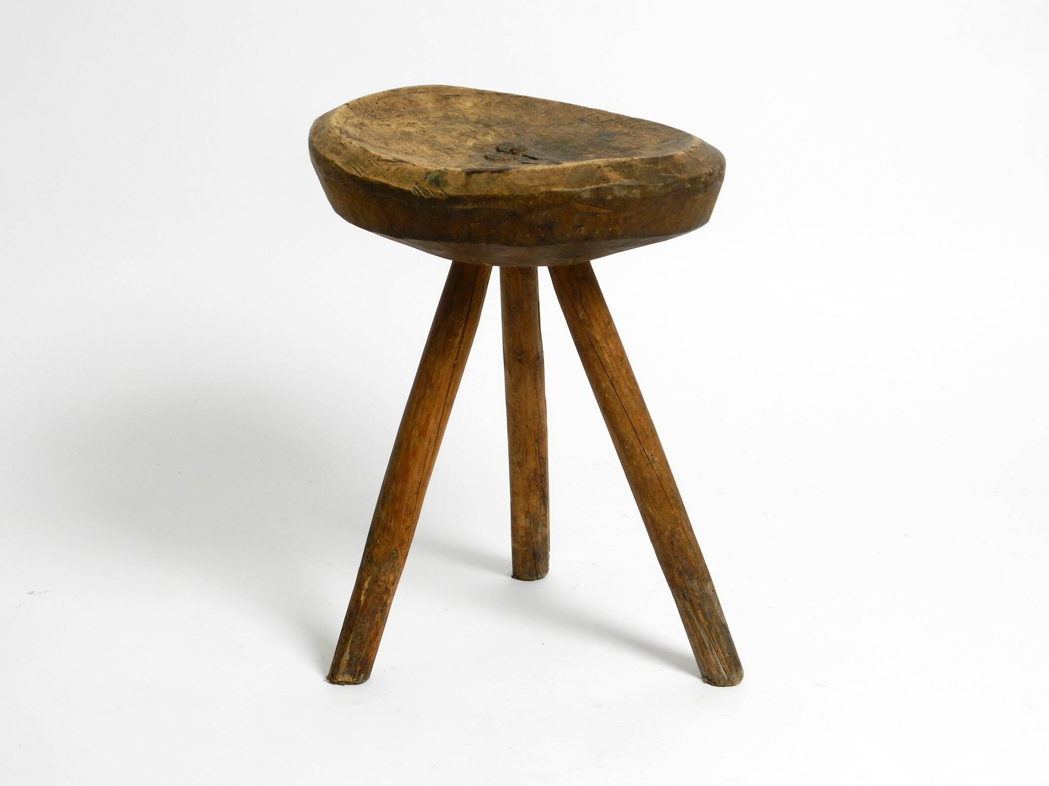 Tabouret en bois massif à trois pieds, sculpté à la main des années 1900, avec une patine fantastique.