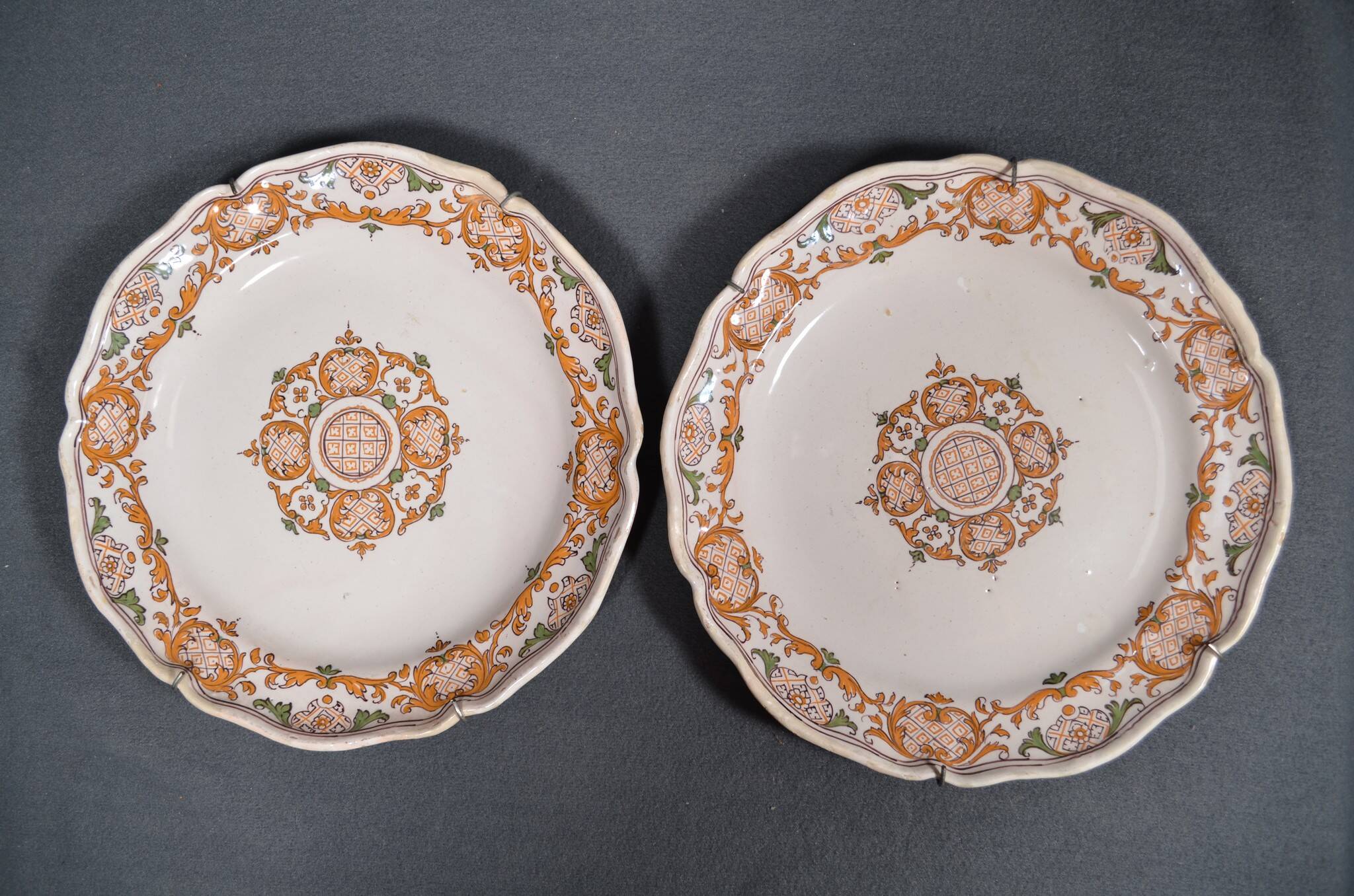 Two 18th century earthenware plates with grand feu decoration in ochre, green and manganese
