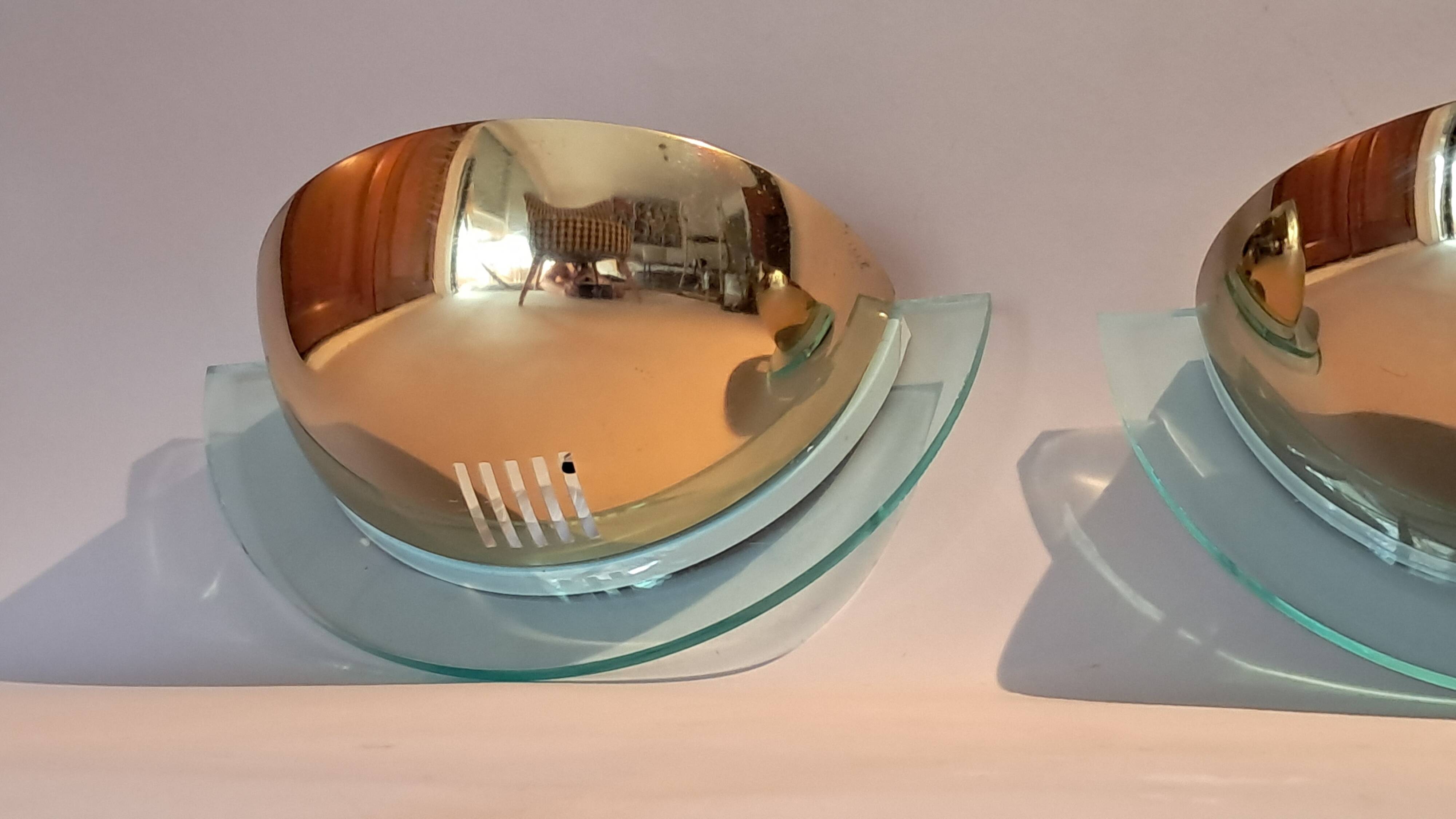Pair of gold metal and plexiglass wall lights, circa 1980.