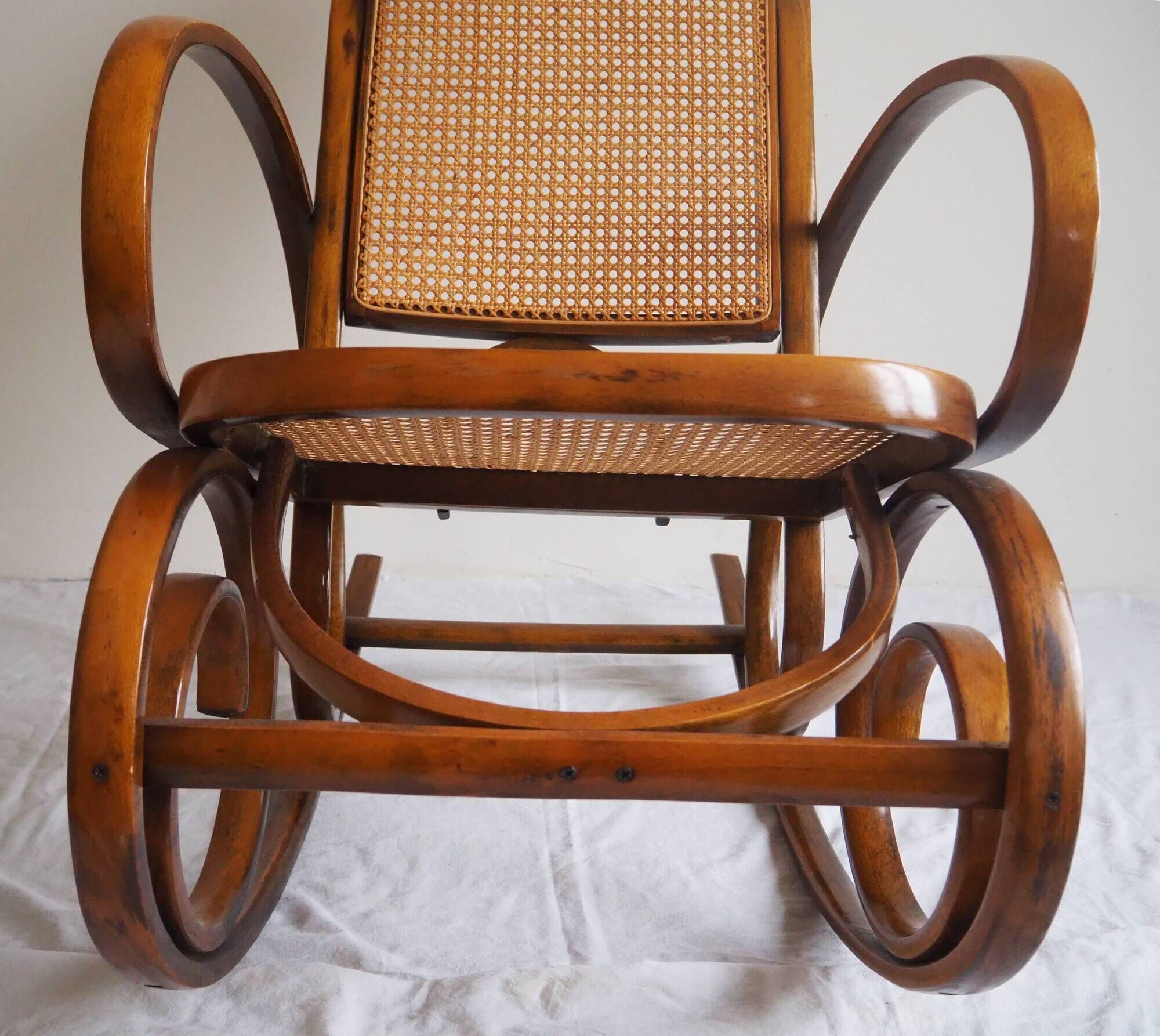 Rocking-chair en bois teinté et assise cannée