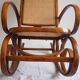Rocking-chair en bois teinté et assise cannée